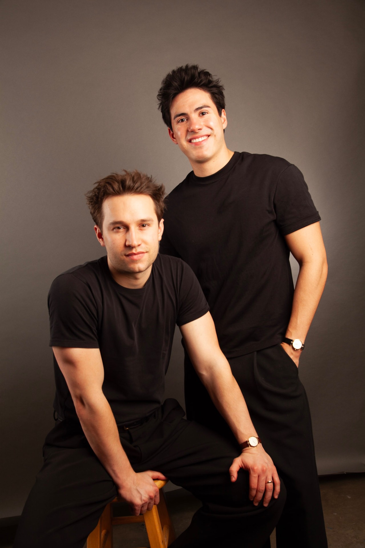 Griffin and Neiyell in black tees in a grey studio portrait